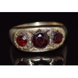 A 9ct gold ring set with three round cut garnets in star settings, 5g, size N