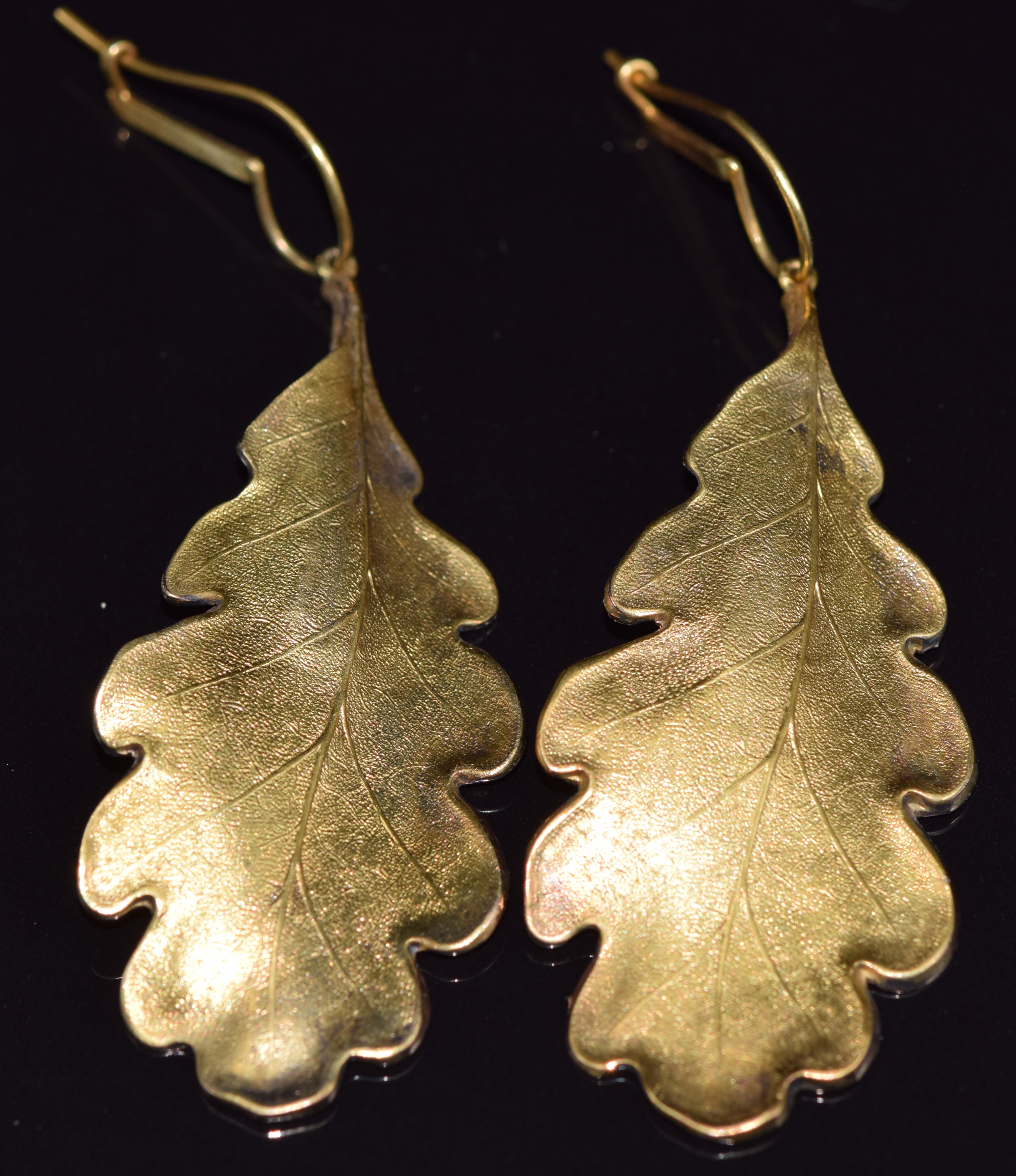 A pair of 14ct gold earrings in the form of an oak leaf with textured decoration, 14g