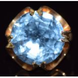 An 18k gold ring set with a round cut blue topaz, 9.3g, size N/O