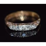 An 18ct gold ring set with five diamonds in a scrolling setting, 2.8g, size N