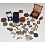 A cased bronze Queen Victoria 1897 commemorative medal, military badges including hallmarked silver,