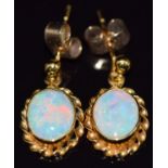 A pair of 9ct gold earrings set with an opal cabochon to each, 2.1g
