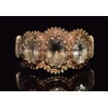 A 9ct gold ring set with three oval cut smoky quartz, Birmingham 1975, 2.8g, size L