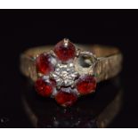 A 9ct gold ring set with a diamond and garnets, 2.7g, size O