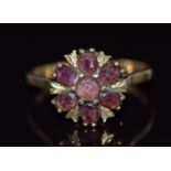 A 9ct gold ring set with a round and oval cut garnets in a cluster, 2.7g, size O