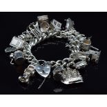 A silver charm bracelet with over 20 charms including boat, St Christopher, car, etc, 103g