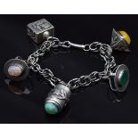 A silver charm bracelet marked 935 with five unusual charms, 52.7g