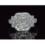 Art Deco platinum ring set with old cut diamonds in a rectangular setting, the tiered shoulders