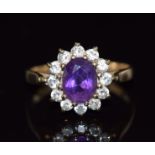 A 9ct gold ring set with an oval cut amethyst surrounded by cubic zirconia, 2.6g, size O