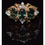 A 14k gold ring set with three oval cut green sapphires and diamonds, 3.9g, size N