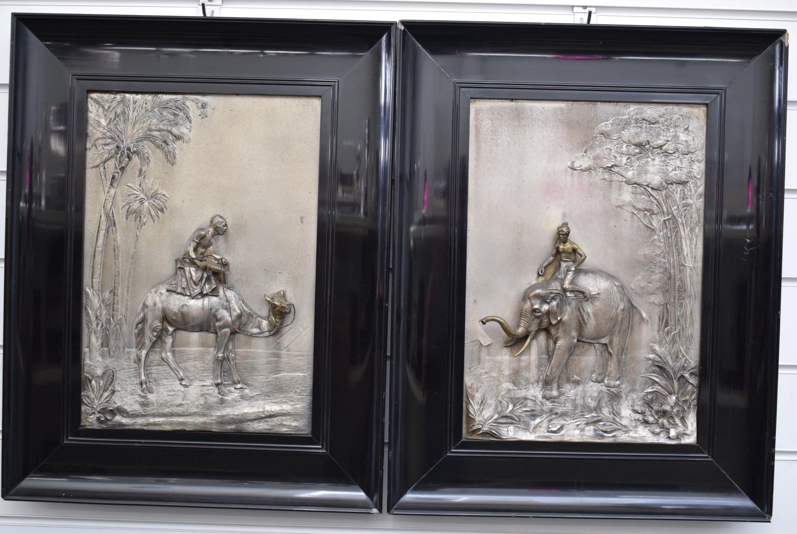 Pair of framed WMF silver plated panels with relief decoration, one depicting a man on camel below