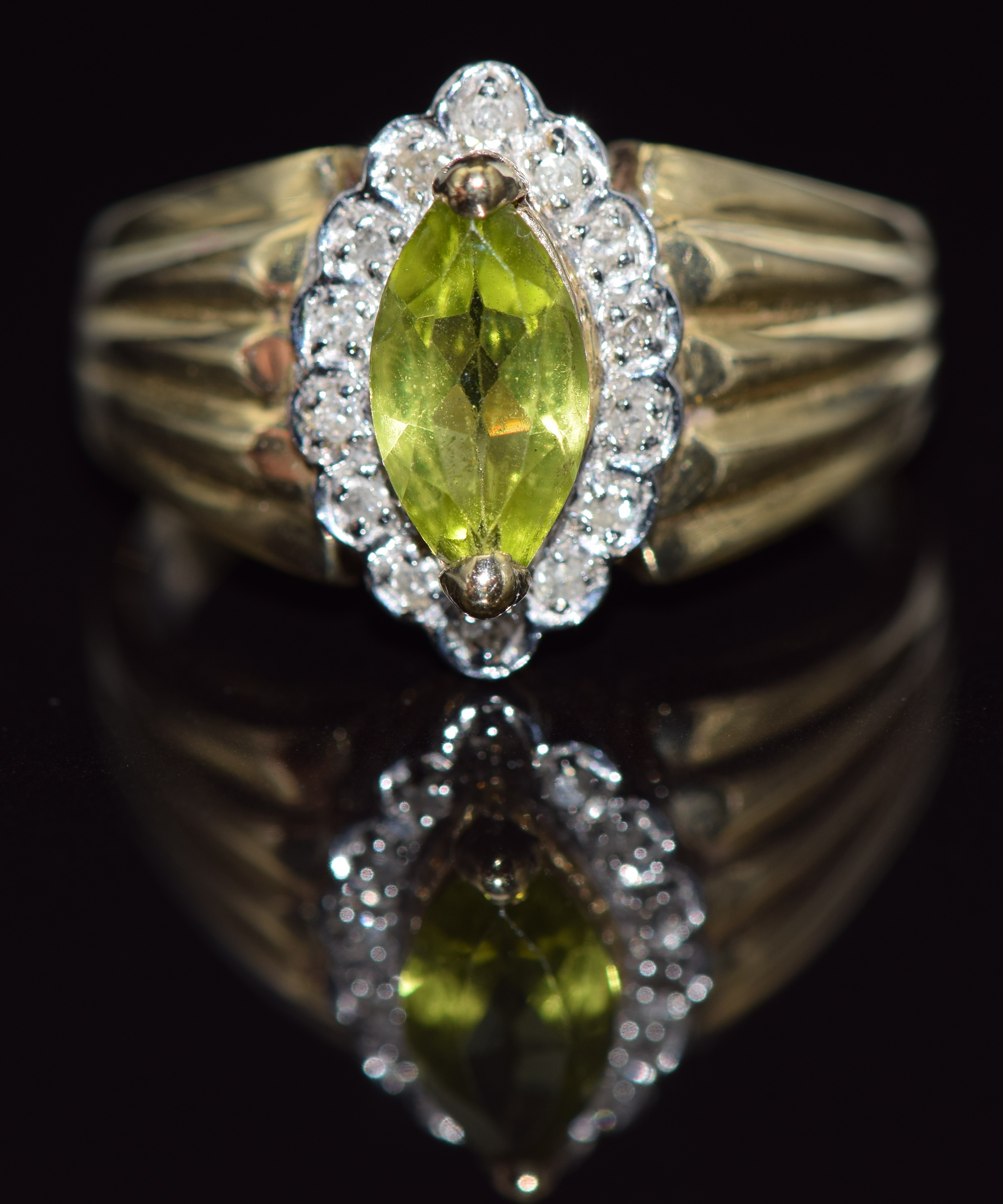 A 9ct gold ring set with a marquise cut peridot surrounded by diamonds, 4.0g, size R