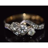 An 18ct gold ring set with three diamonds, the largest diamond approximately 0.25ct, in a platinum