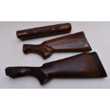 Two semi-pistol grip shotgun stocks, one Remington with carved decoration and matching forend.