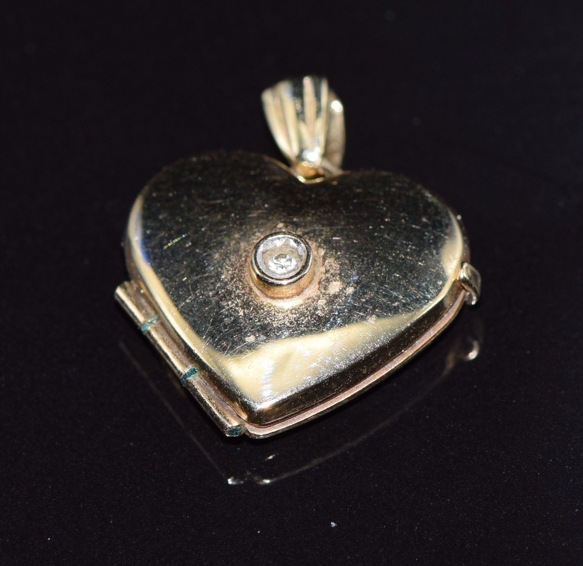 A 9ct gold locket set with a diamond, 1.4g