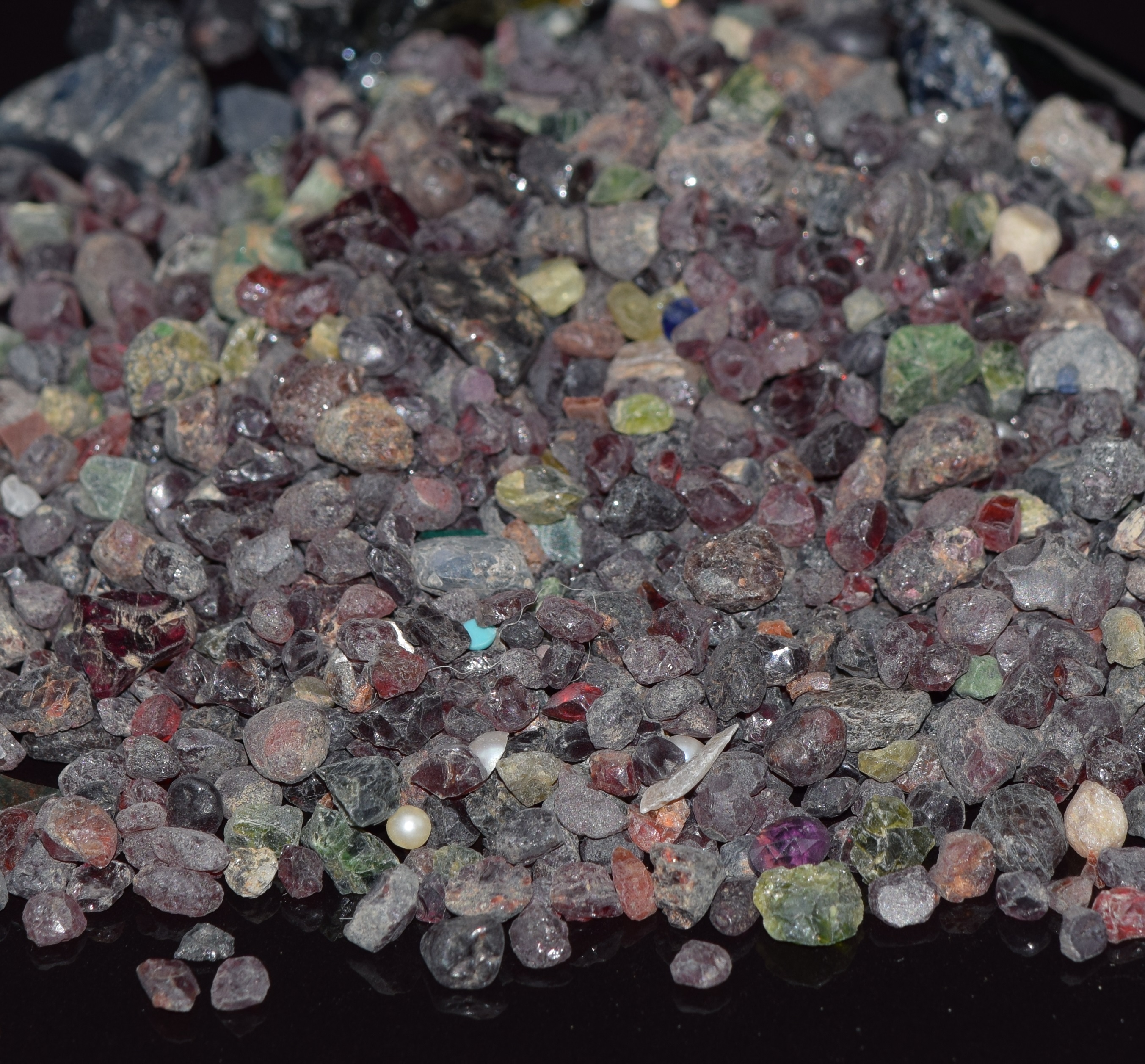 A quantity of loose rough sapphire, ruby and garnet