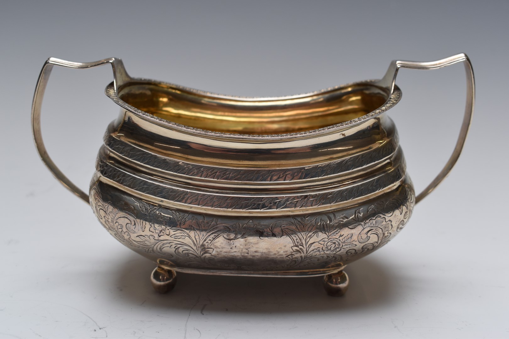 Georgian white metal sugar bowl with gilt wash interior, engraved decoration and twin handles, width