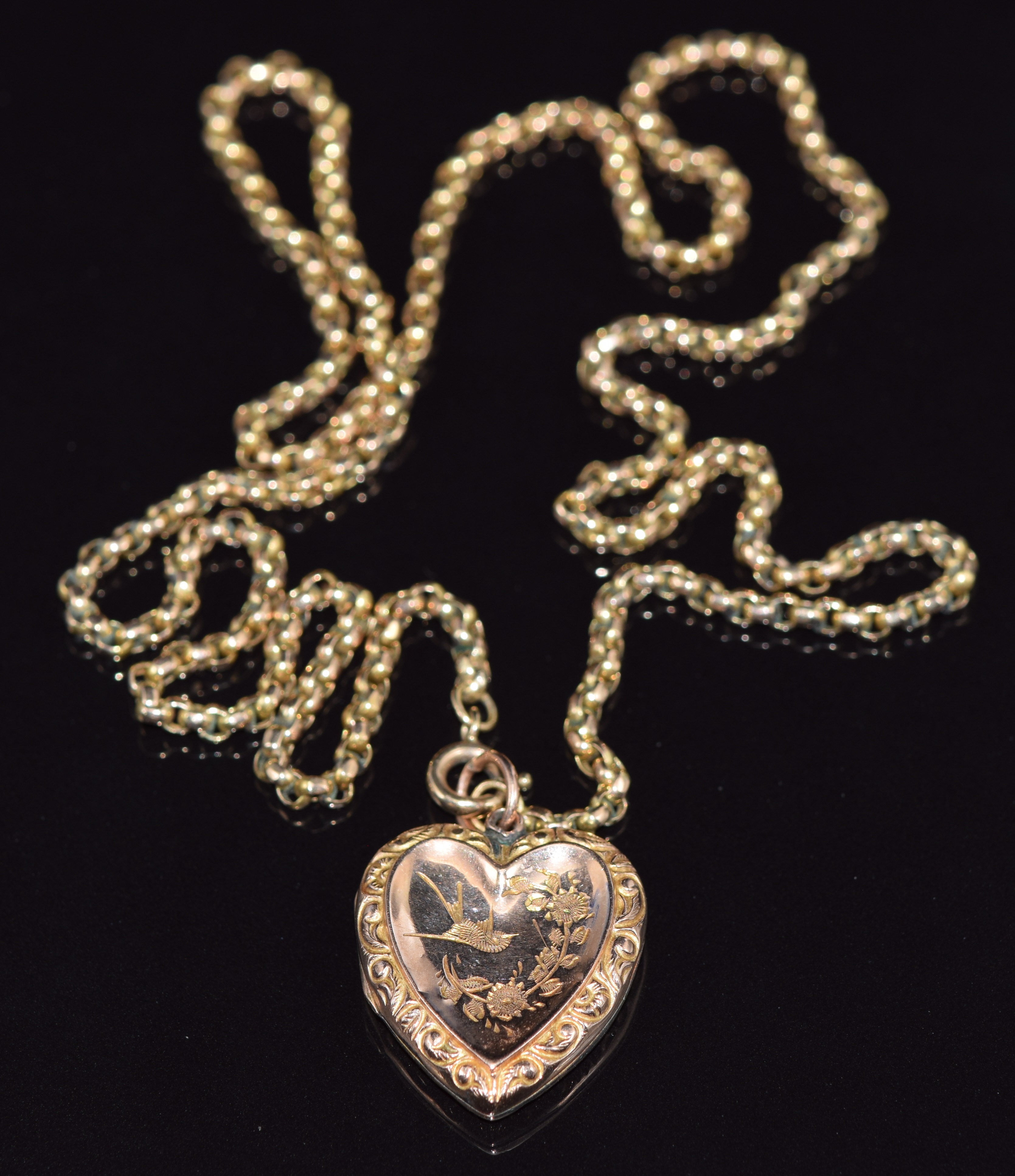 A 9ct gold necklace made up of faceted links and a 9ct back and front heart locket with swallow