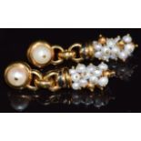 A pair of 18ct gold earrings set with a pearl to the stud and a further elongated cluster of pearls,