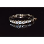 A c1900 silver bangle set with moonstones and seed pearls