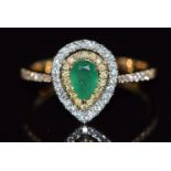 An 18ct gold ring set with a pear cut emerald surrounded by yellow diamonds and diamonds, 3.1g, size