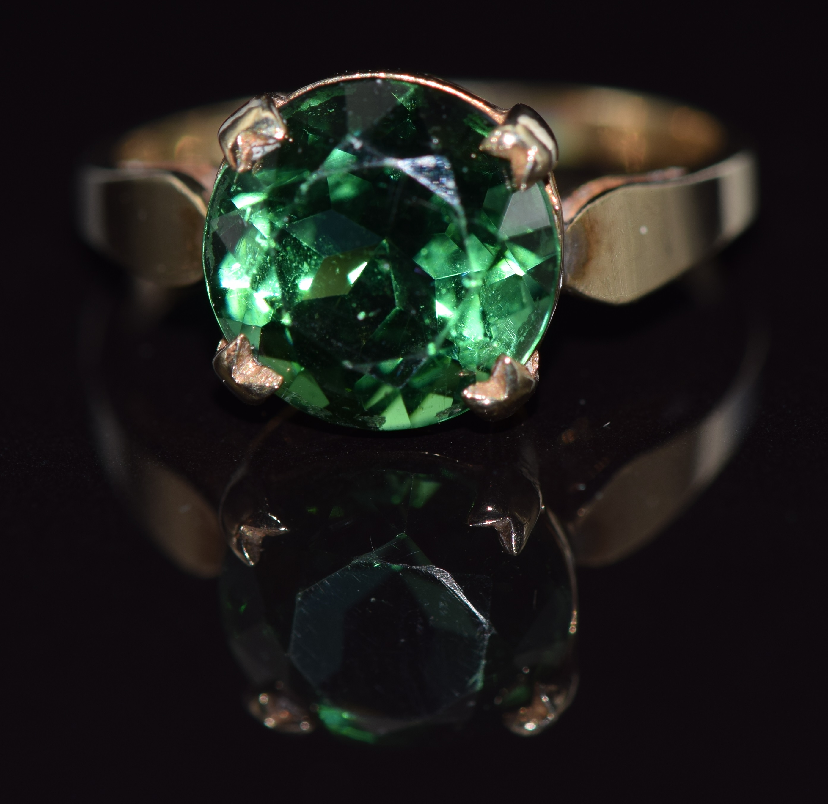 A 9ct gold ring set with a round cut green topaz, 2.9g, size L