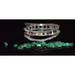 A white gold ring mount together with loose emeralds