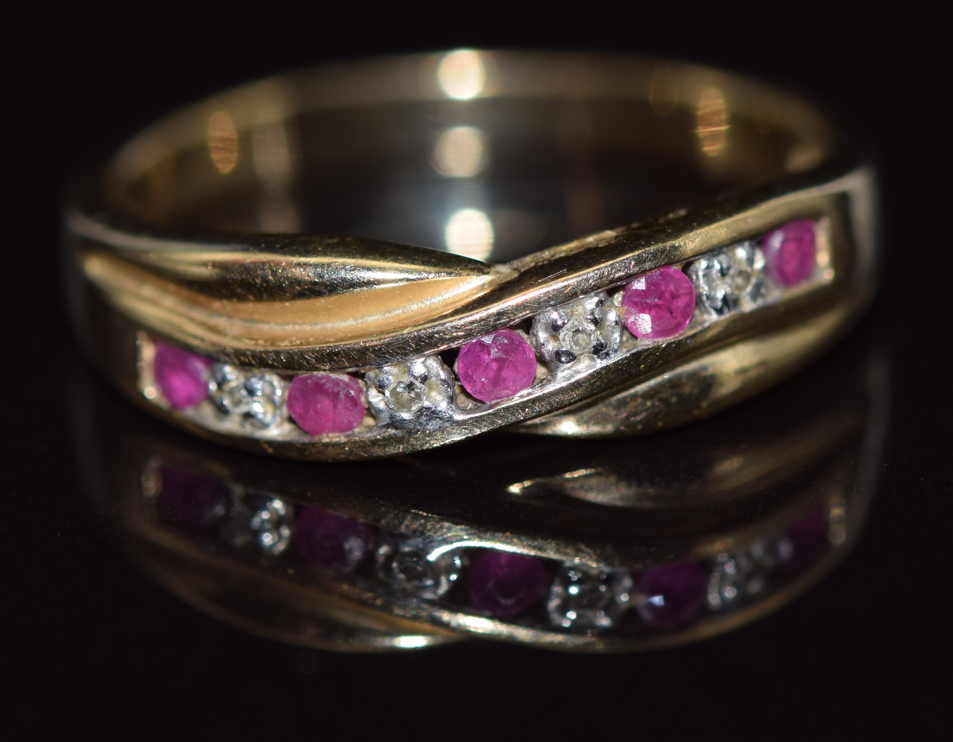 A 9ct gold ring set with diamonds and rubies in a twist setting, 2.8g, size O