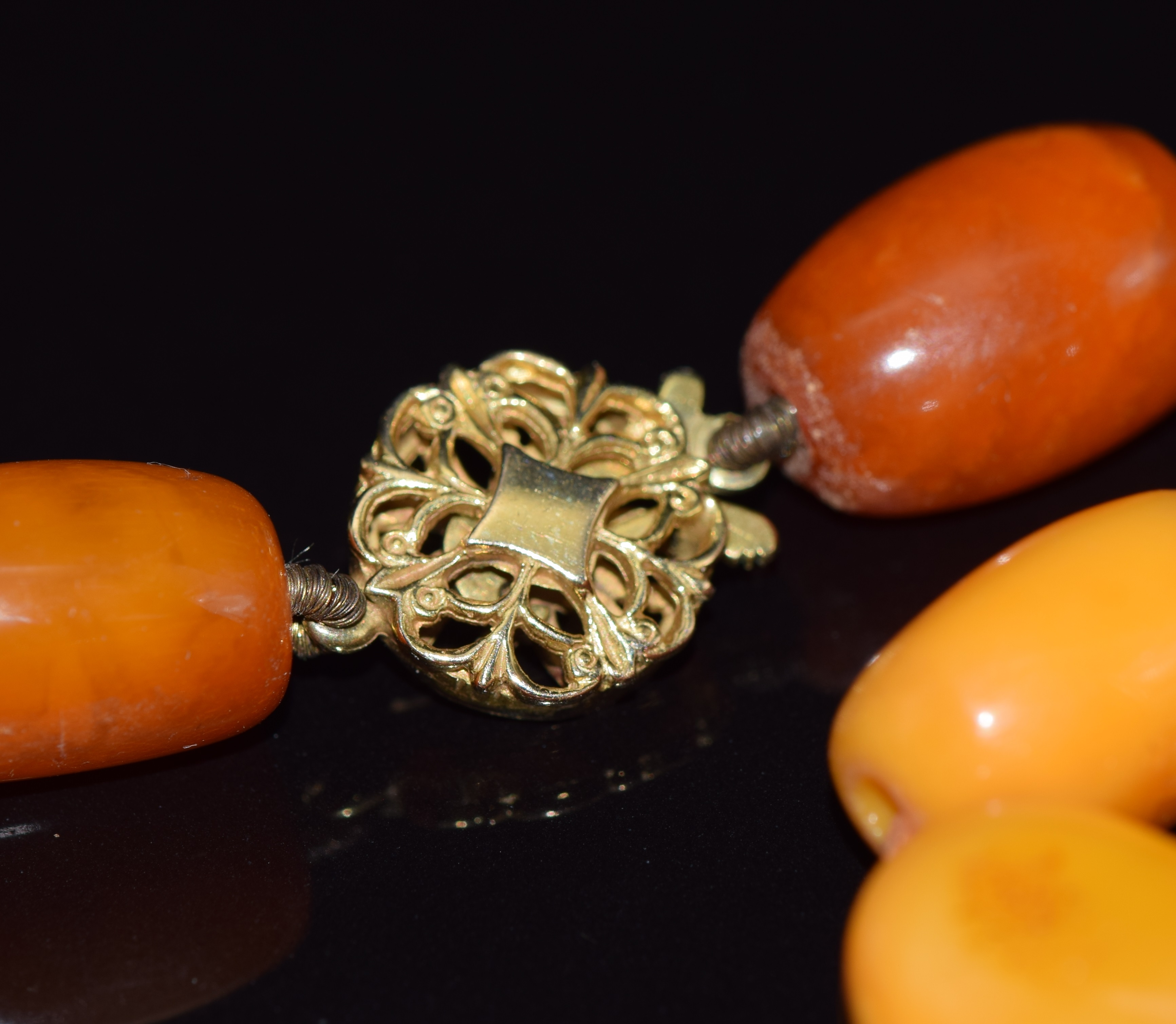 Baltic amber necklace made up of 36 oval beads with a 9ct gold pierced clasp, 47.2g, largest bead - Image 2 of 2