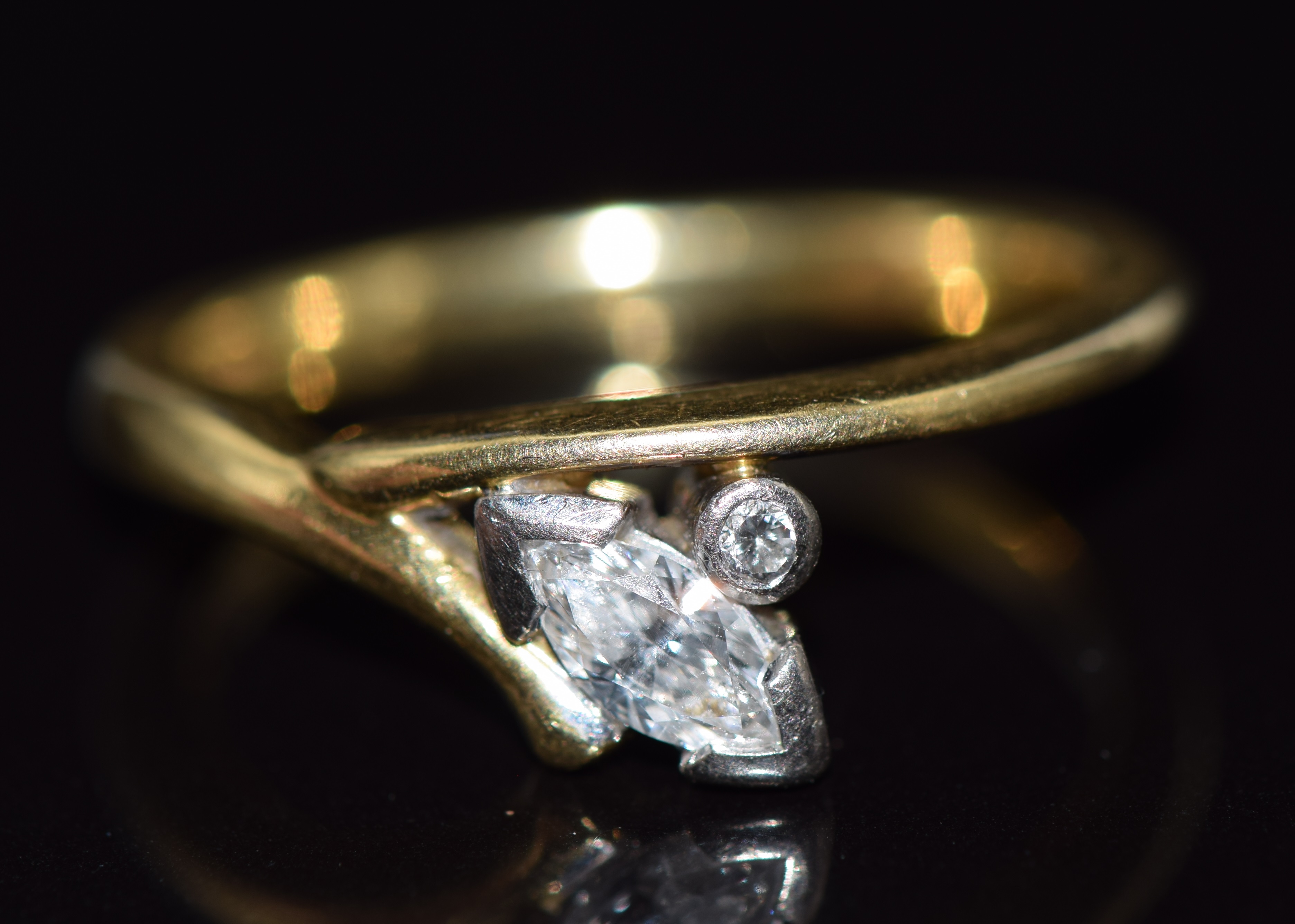 An 18ct gold ring set with a marquise cut diamond of approximately 0.27ct and a round cut diamond,