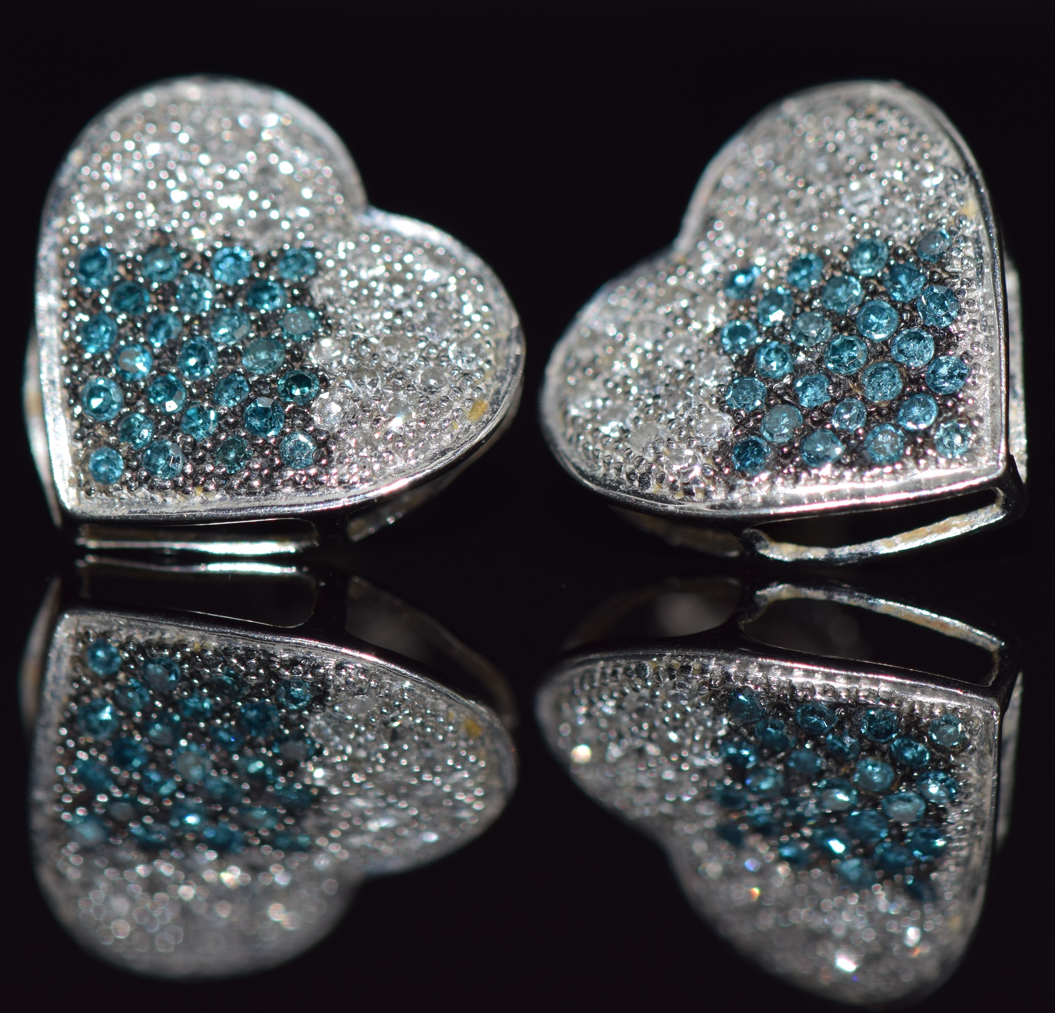 A pair of 10k white gold earrings in the form of hearts, set with blue and clear diamonds, 1.8g