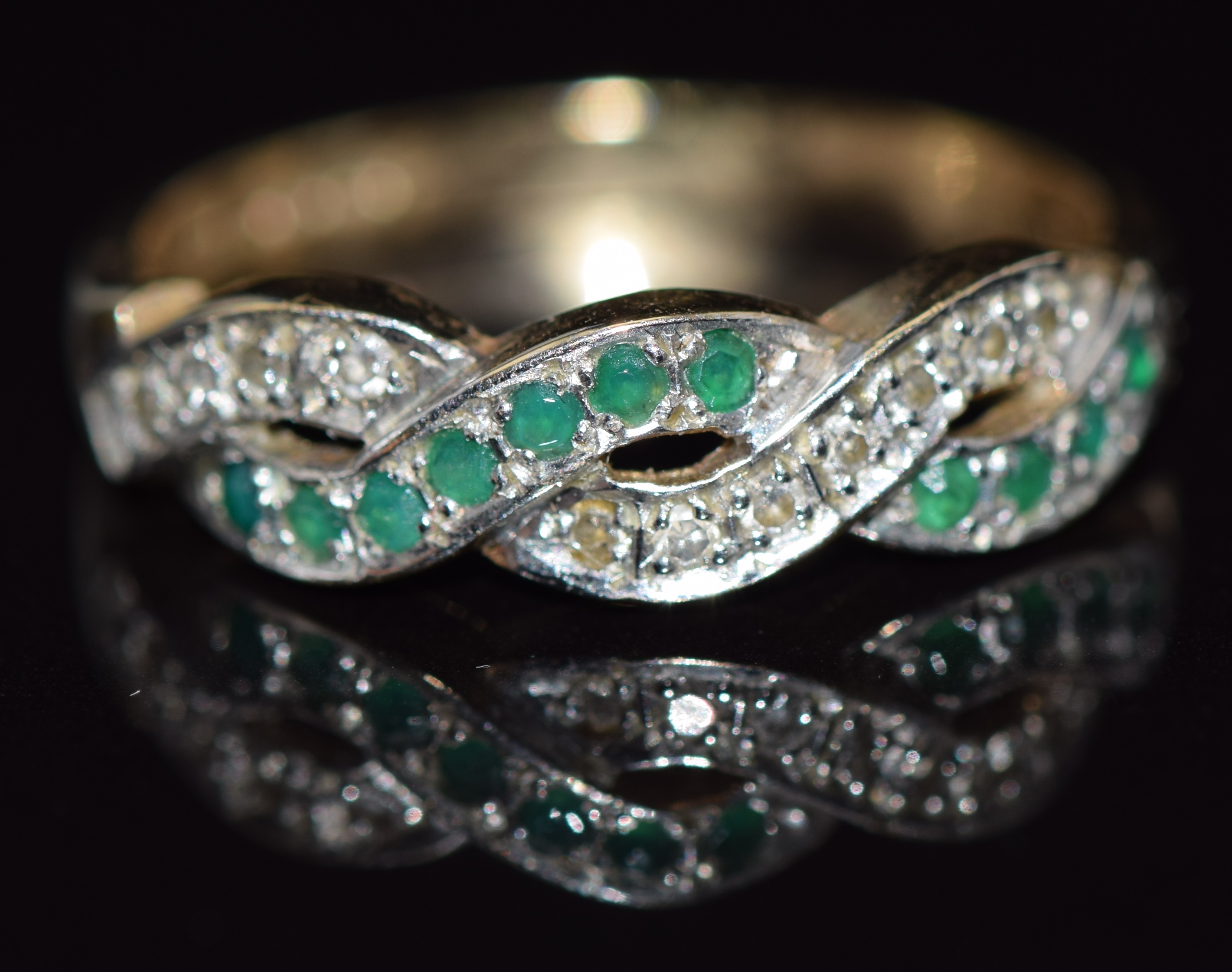 A 9ct gold ring set with emeralds and diamonds in a twist setting, 2.6g, size P