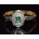 An 18ct gold ring set with an emerald and diamonds in a platinum setting, 2.4g, size N