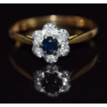 An 18ct gold ring set with a sapphire surrounded by diamonds, 2.3g, size O