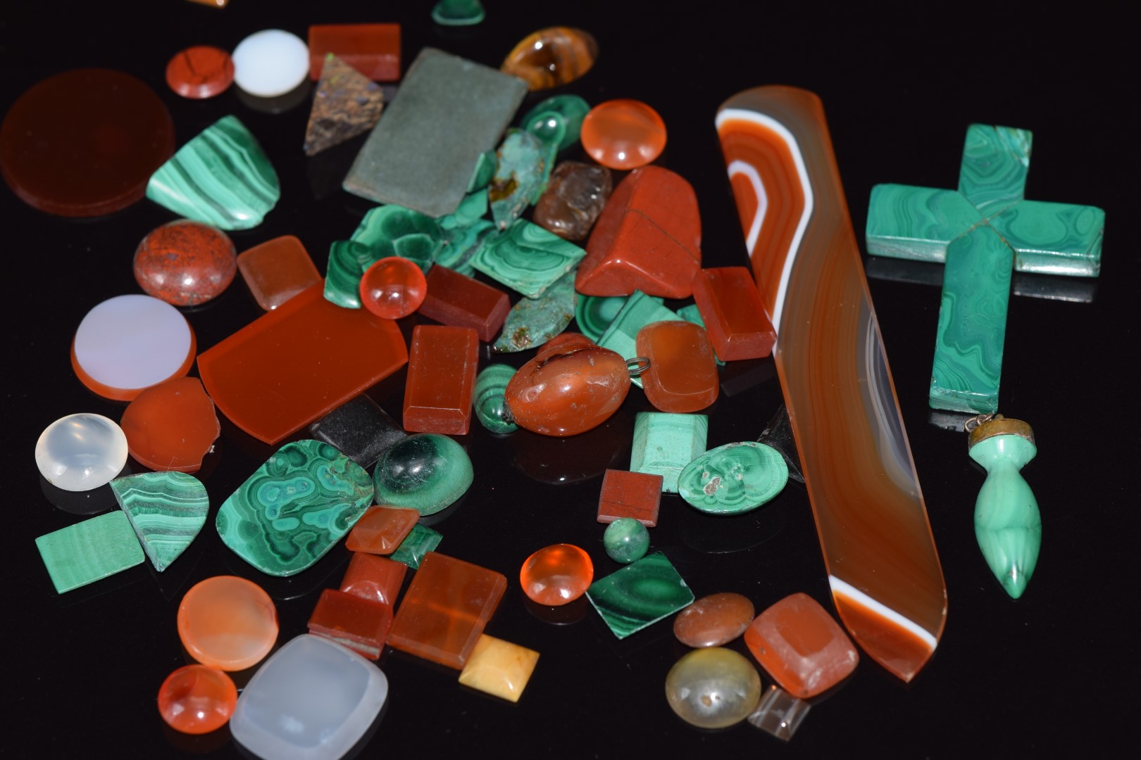 A collection of loose malachite and carnelian agate cabochons and plaques