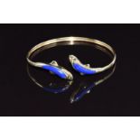 A 14ct gold bangle in the form of two dolphins set with lapis lazuli, 9.4g