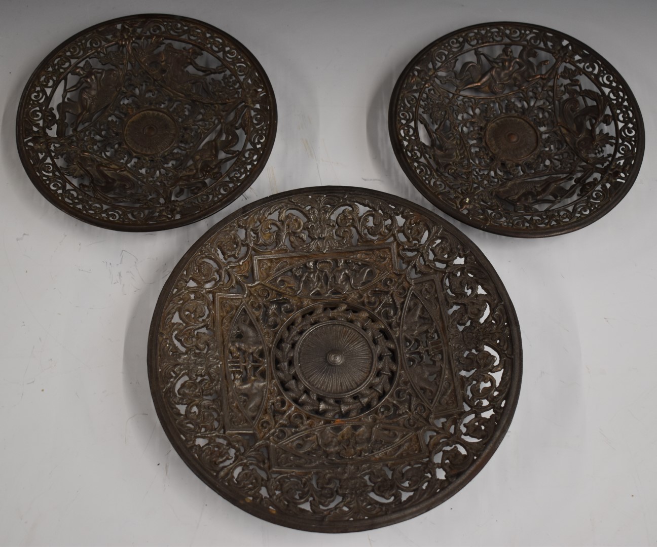 A pair of Coalbrookdale bronze dishes with pierced decoration of Greek gods atop fish and mythical