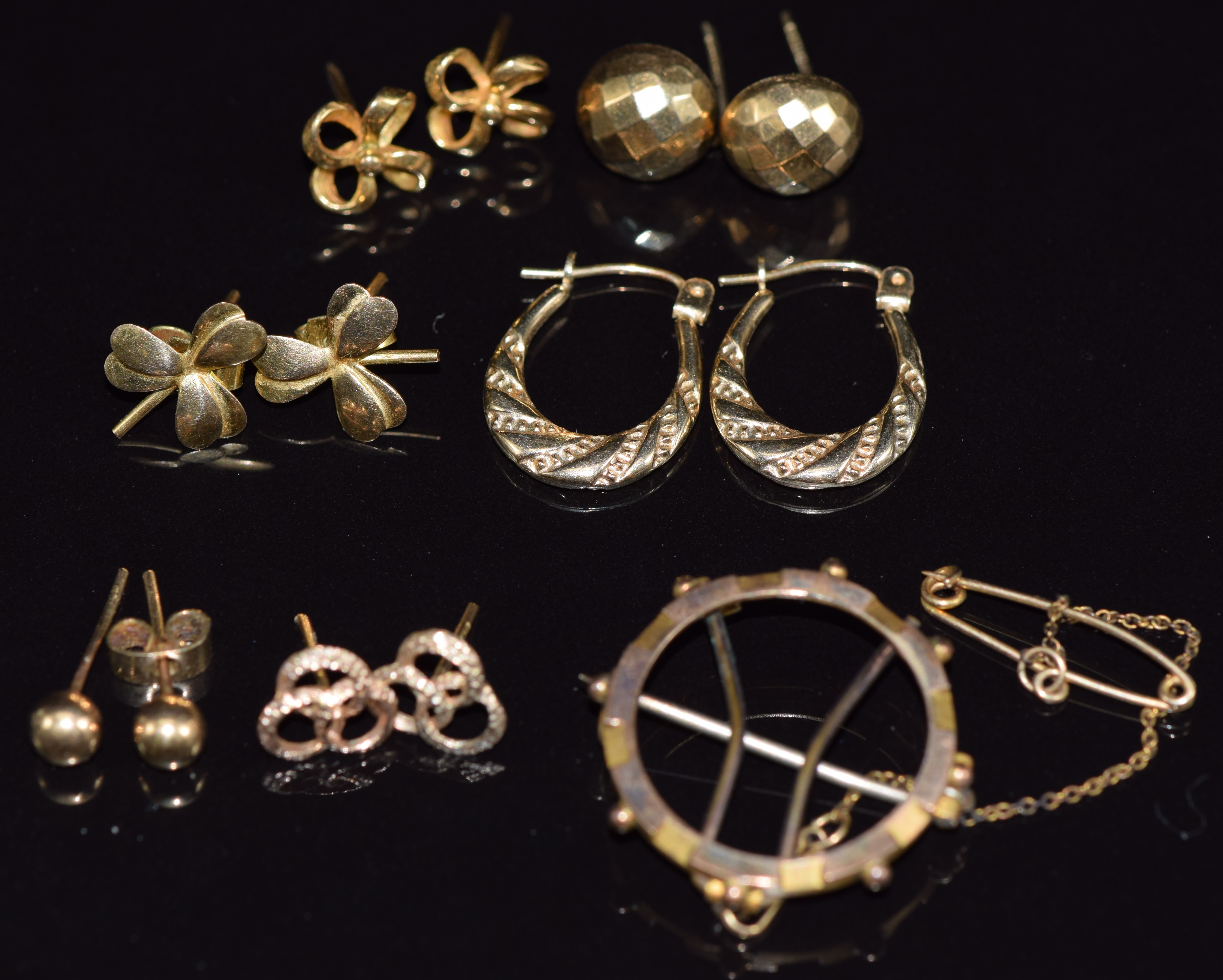 A collection of 9ct gold earrings including hoop , faceted, clover, bow, etc and a 9ct gold mount,