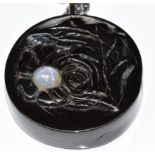 A carved black coral pendant depicting a shark and verso a flower set with a star sapphire, 3.5cm