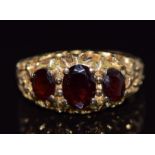 A 9ct gold ring set with three oval cut garnets, 4.2g, size M