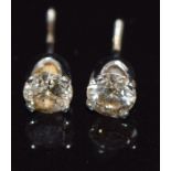 A pair of white metal stud earrings set with a round cut diamond of approximately 0.3ct to each, 0.