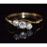 An 18ct gold ring set with three diamonds in a twist setting, 2g, size L