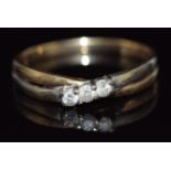 A 9ct gold ring set with three diamonds in a twist setting, 1.5g, size O
