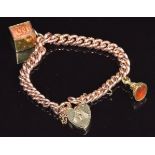 A 9ct rose gold bracelet with a 9ct gold ten shilling note charm and a Victorian fob set with agate,