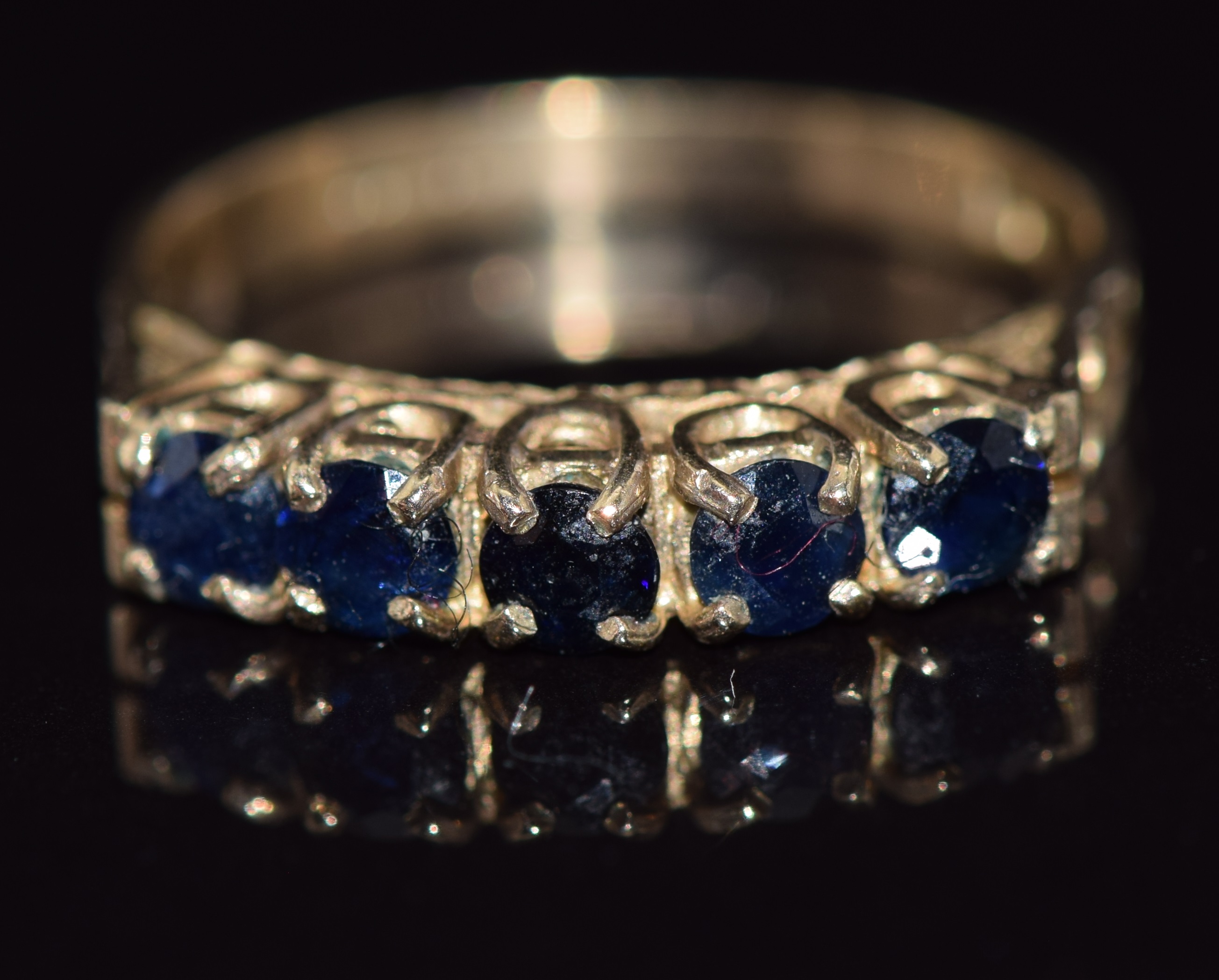 A 9ct gold ring set with five round cut sapphires, 2.4g, size M/N