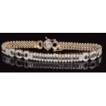 A 9ct gold tennis bracelet set with diamonds and black diamonds in three rows with buckle