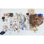 A collection of costume jewellery including necklaces, enamel and marcasite brooch, earrings, rolled