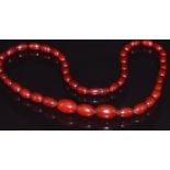 A  cherry amber necklace made up of 43 graduated oval beads, 33.6g, largest bead 2 x 1.3cm