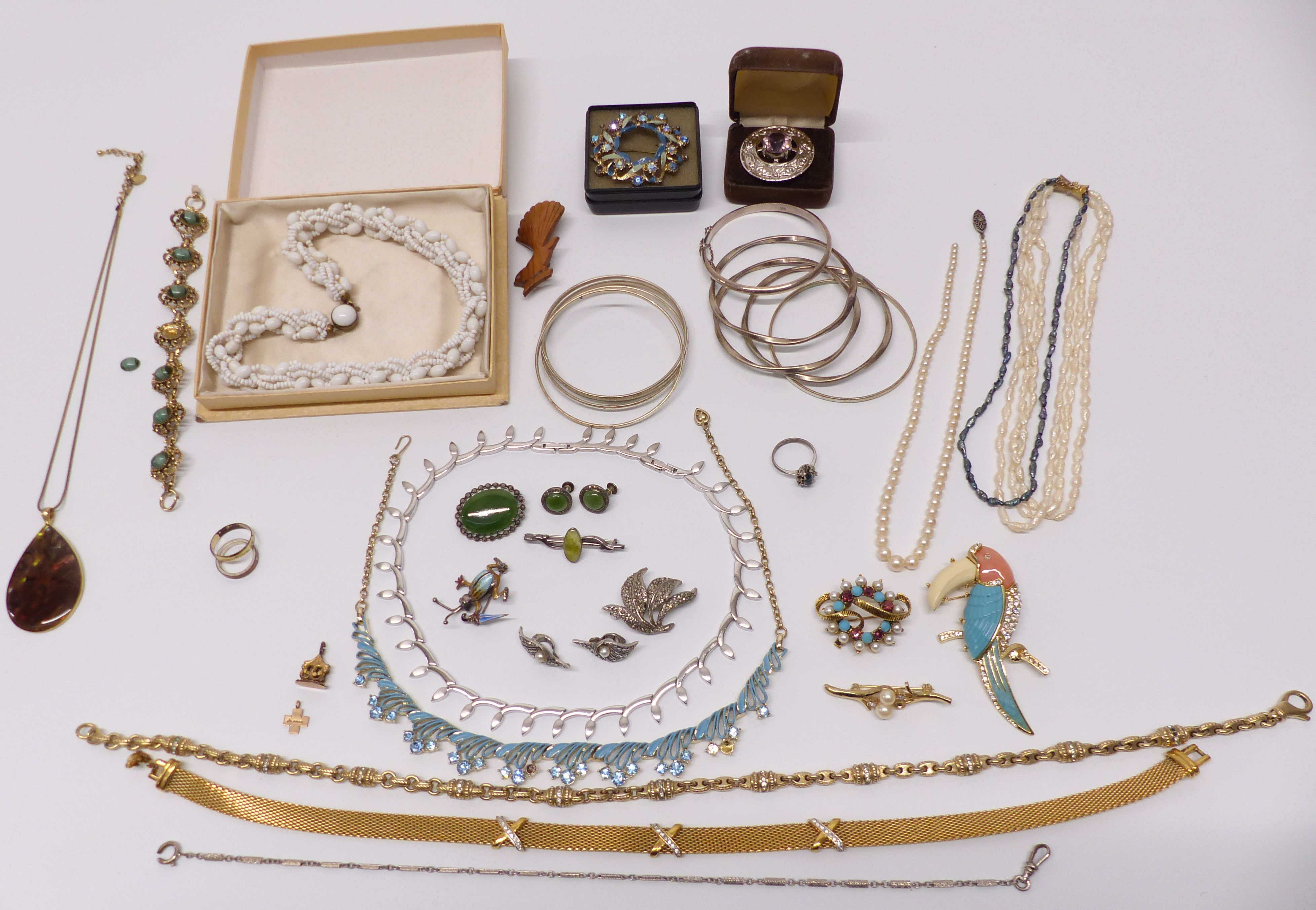 A collection of costume jewellery including pearl necklace, silver bangle, silver brooch depicting a