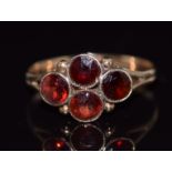 A 9ct gold ring set with four round cut garnets, 1.5g, size O
